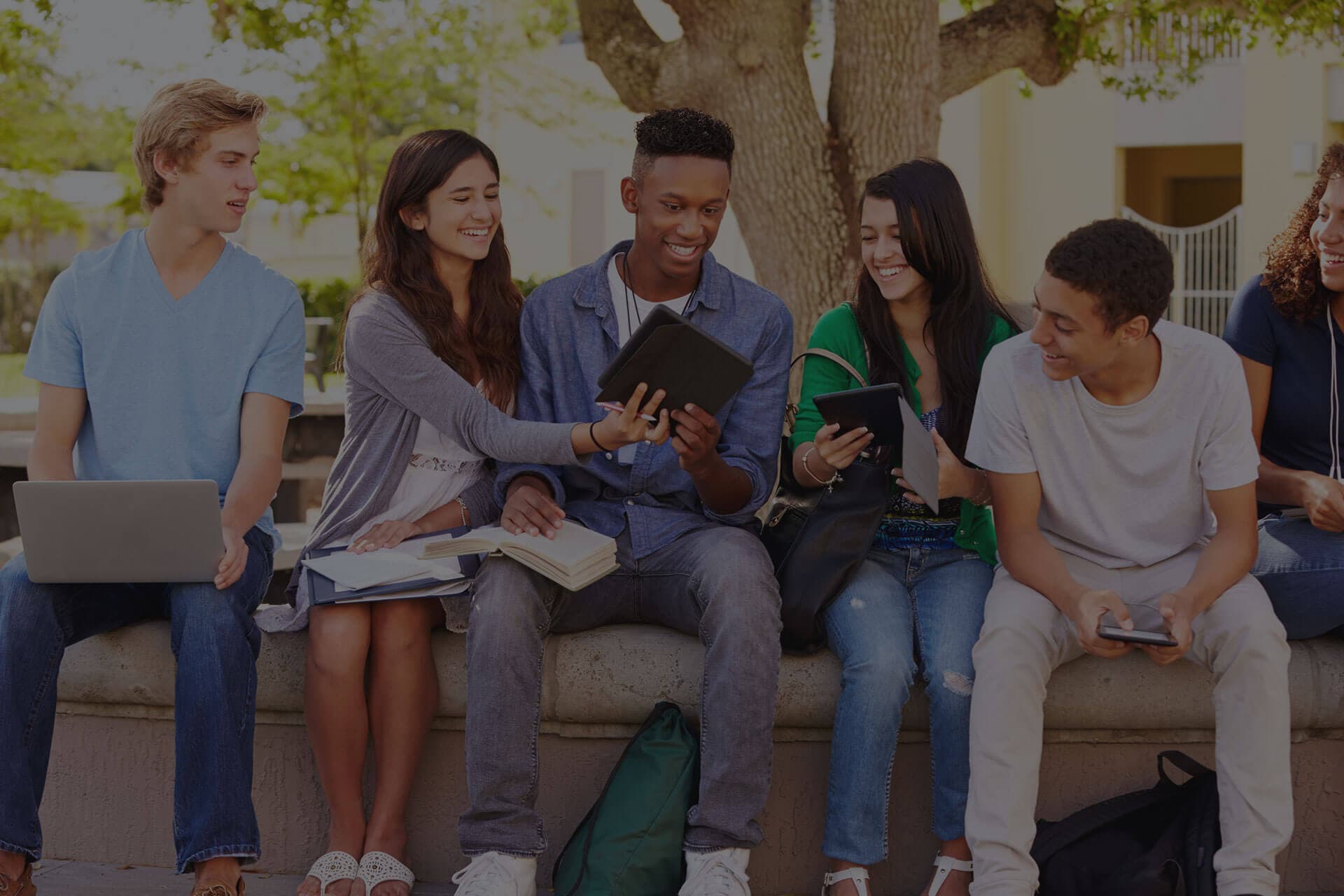 Group of diverse students with laptops and tablets in collaborative learning environment